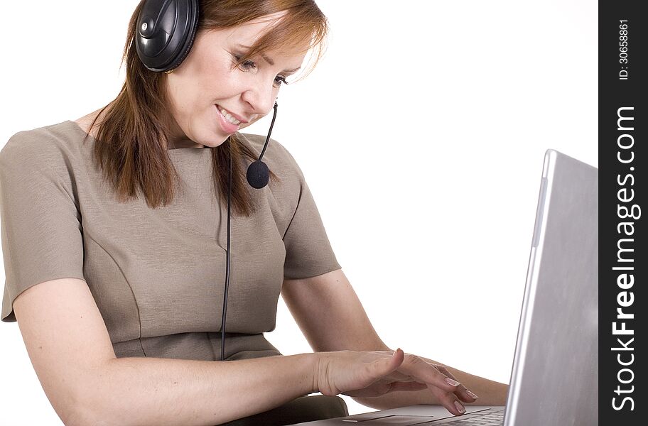 Portrait of pretty call operator smiling and typing on lap top