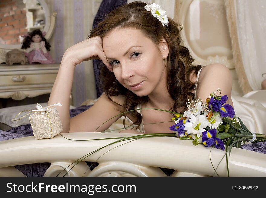 Woman with flowers in bed, bride in luxury interior