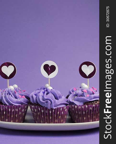 Mauve purple decorated cupcakes for children or teens birthday, or bachelorette, bridal or baby shower party function. Vertical with copy space for your text here. Mauve purple decorated cupcakes for children or teens birthday, or bachelorette, bridal or baby shower party function. Vertical with copy space for your text here.