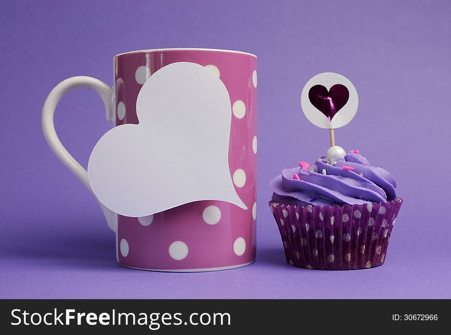 Mauve purple decorated cupcakes for children or teens birthday, or bachelorette, bridal or baby shower party function, with pink polka dot coffee mug and heart gift tag with copy space for your text here. Mauve purple decorated cupcakes for children or teens birthday, or bachelorette, bridal or baby shower party function, with pink polka dot coffee mug and heart gift tag with copy space for your text here.