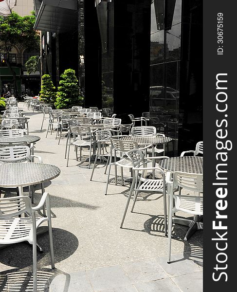 Empty tables and chairs of a sidewalk coffee shop in Ho chi minh city, Vietnam