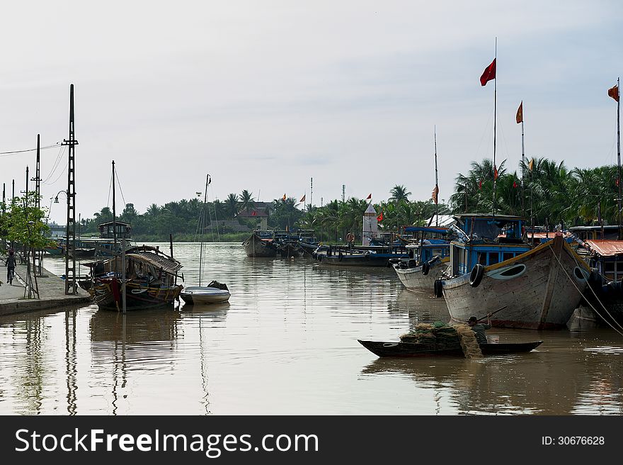 Man rowing a boat with the fishing net on the river of Hoi An