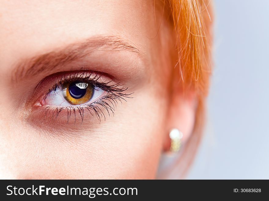 Eye of young beautiful woman with red hair