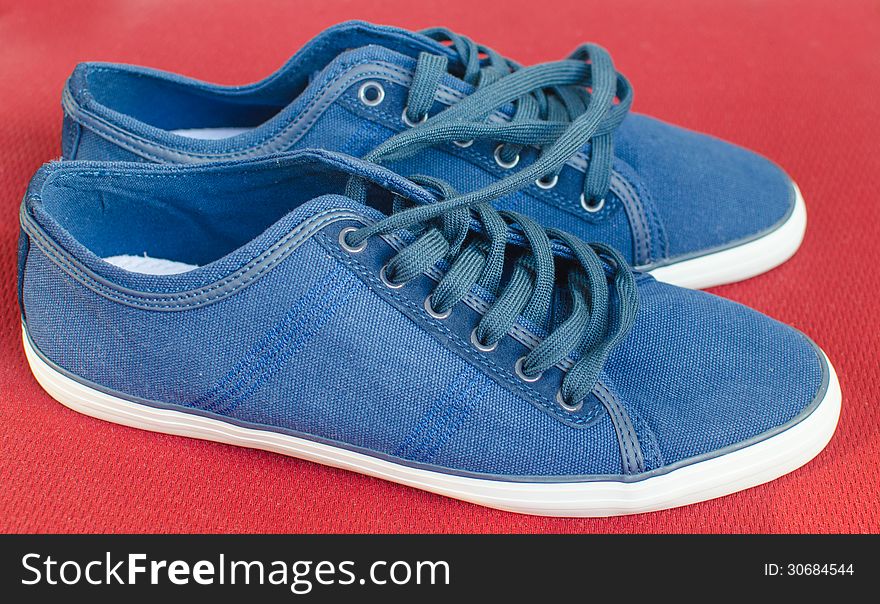 Blue sneakers on red background