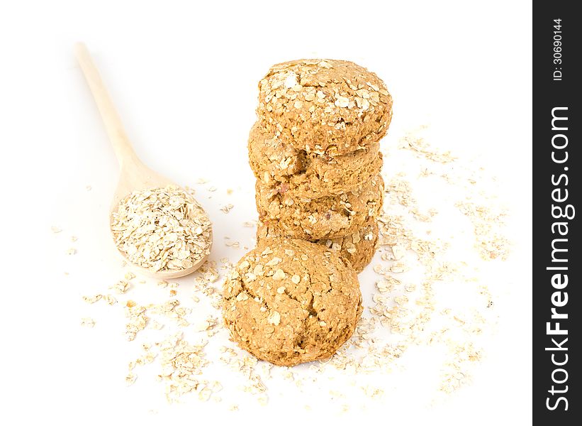 Oatmeal in the wood spoon and cookies on white background