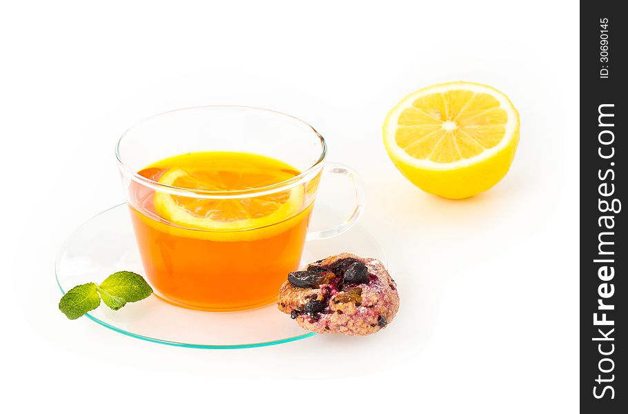 Tea with lemon, cookie and mint on white background, closeup