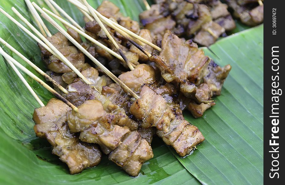 Pig roasting on a banana leaf