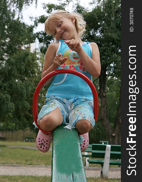 Pretty childhood girl swaying on the balance swing