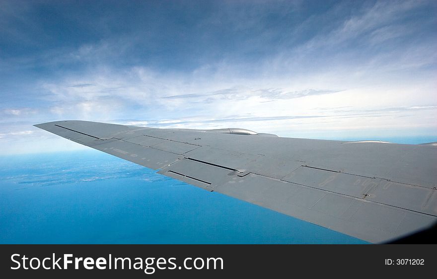 Sky and wing of a KC-135 military jet, in flight with a blue sky background. Sky and wing of a KC-135 military jet, in flight with a blue sky background