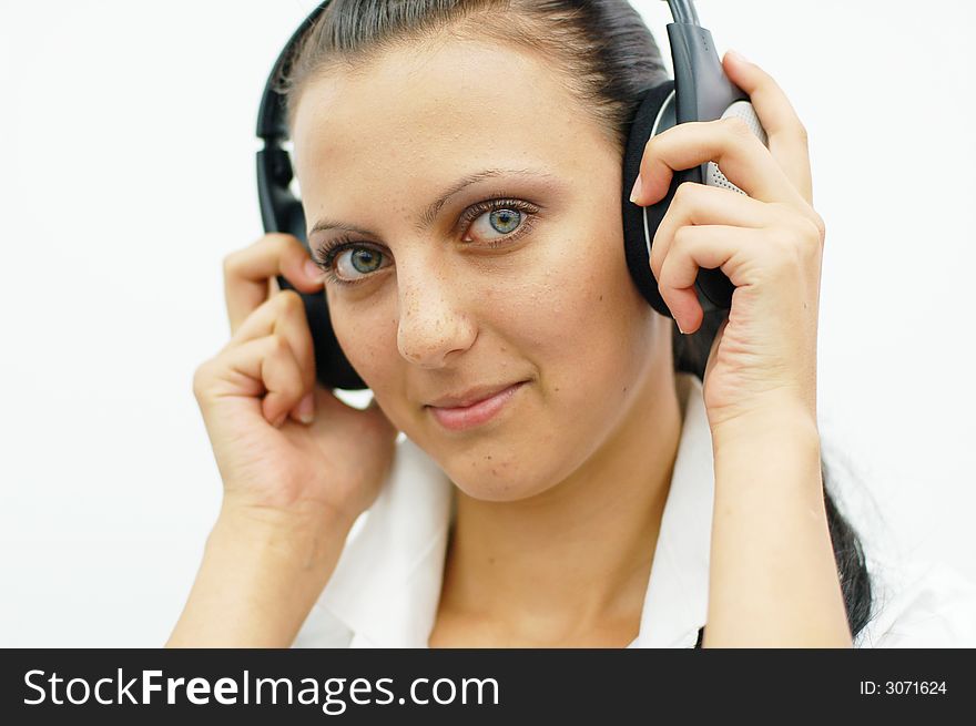 Brunette girl listening music with headphones isolated on white background