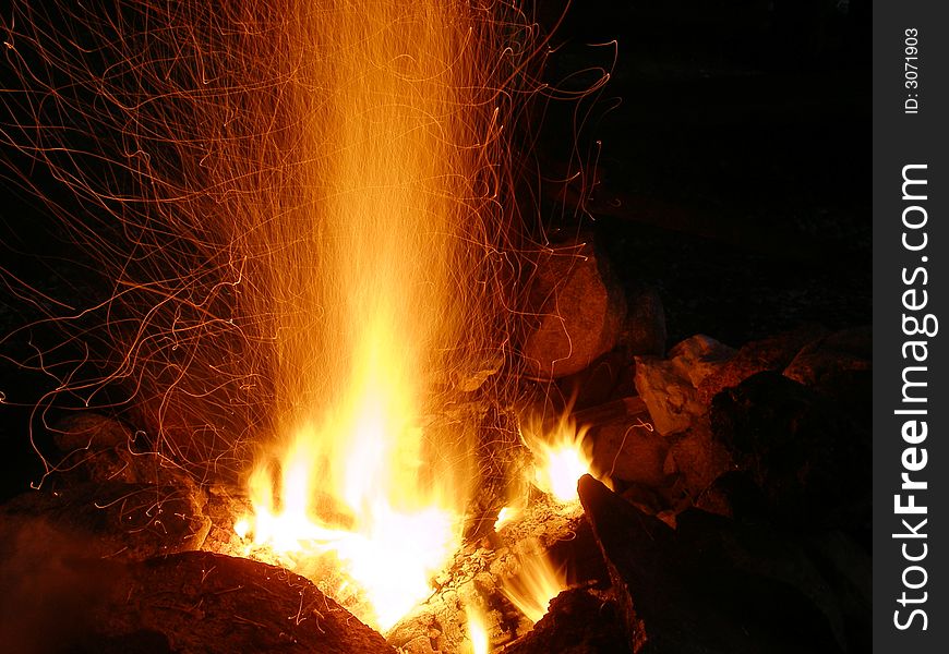 Small but sparkly campfire built outdoors to bring some warmth and light in the night. Small but sparkly campfire built outdoors to bring some warmth and light in the night.