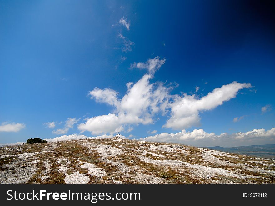 Mountain landscape with white clouds in  dark blue sky. Mountain landscape with white clouds in  dark blue sky