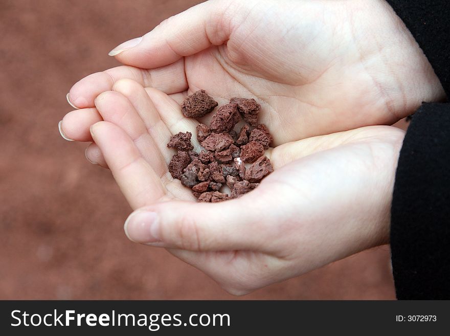 Hands Holding Volcanic Stones