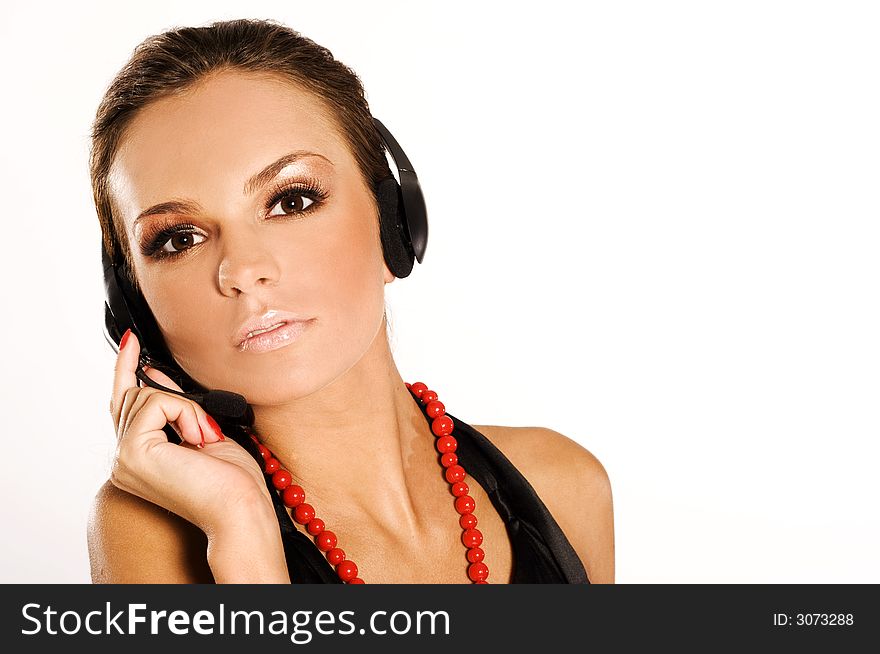 Beautiful girl with dark hair with headphones and microphone on light background. Beautiful girl with dark hair with headphones and microphone on light background