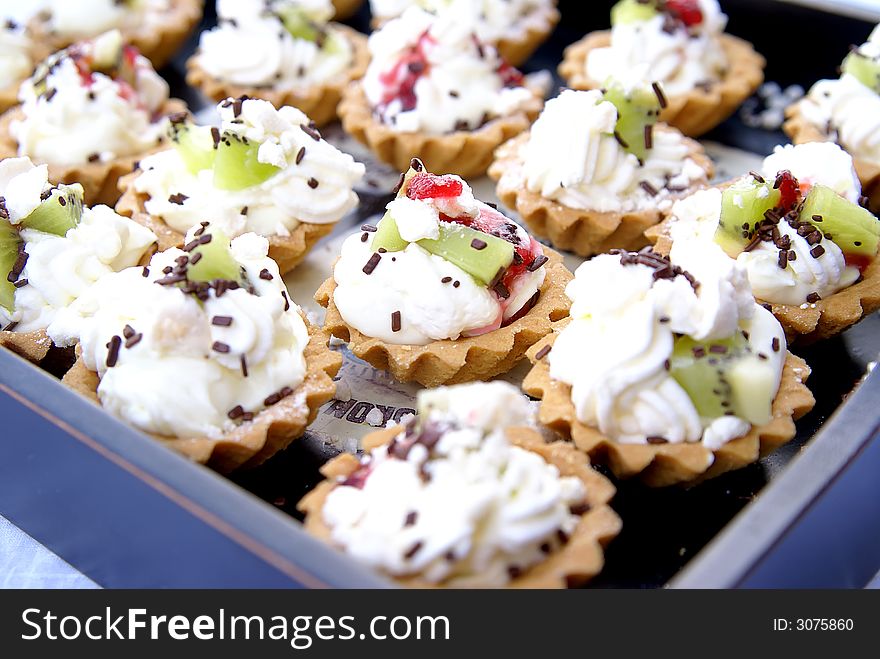 Delicious fruit tart with whipped cream on tray