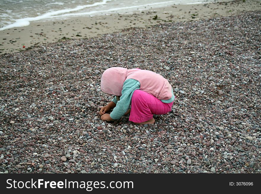 A girl playing with stones on the coast of Baltic sea. A girl playing with stones on the coast of Baltic sea