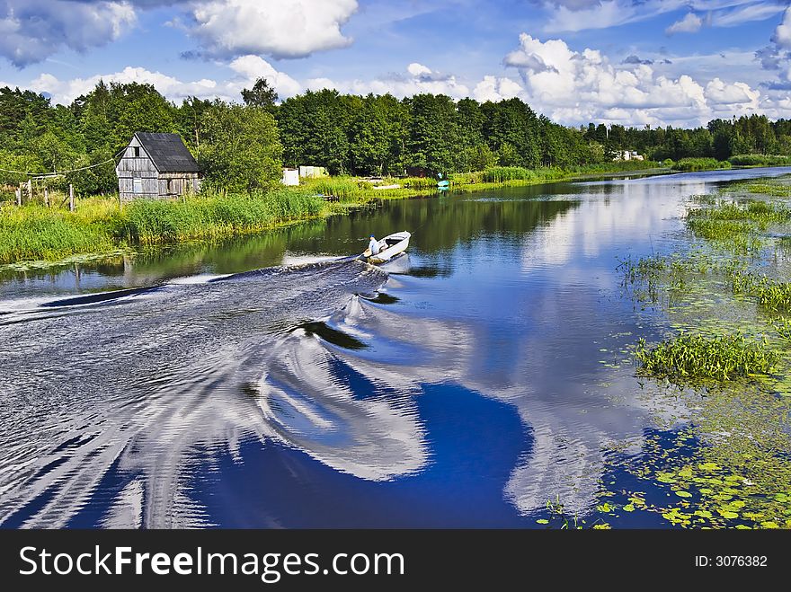 Motor boat on the river with reflection of the cloudy sky at the countryside. Motor boat on the river with reflection of the cloudy sky at the countryside