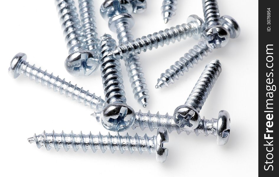 Macro Close-Up Of Spiral Metal Screws On A White Background, Focus On Front