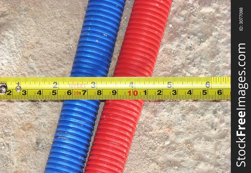 Yellow metallic ruler on blue and red tubes. Yellow metallic ruler on blue and red tubes.