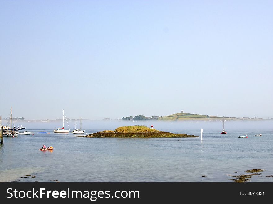 Island at a town of Ireland, with lighthouse and ships navigating