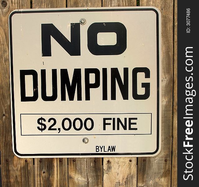 A sign warns of a fine for dumping. A sign warns of a fine for dumping.