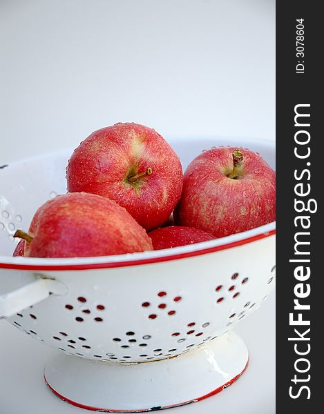 Red gala apples in white and red colander, white background. Red gala apples in white and red colander, white background