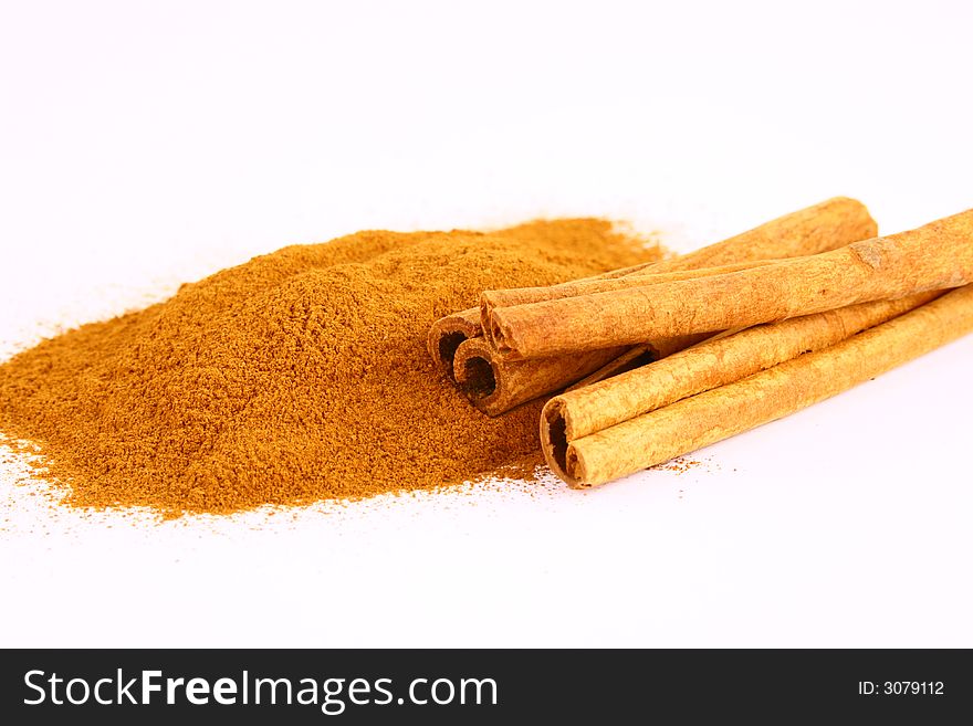 Sticks and powder of cinnamon reflected on the white background