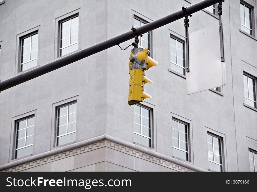 A traffic signal with a building in the middle of downtown. A traffic signal with a building in the middle of downtown.