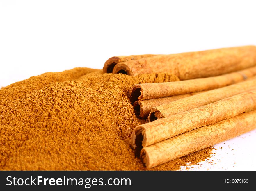 Sticks and powder of cinnamon reflected on the white background