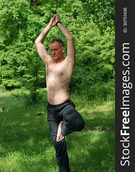 A man practices yoga in nature