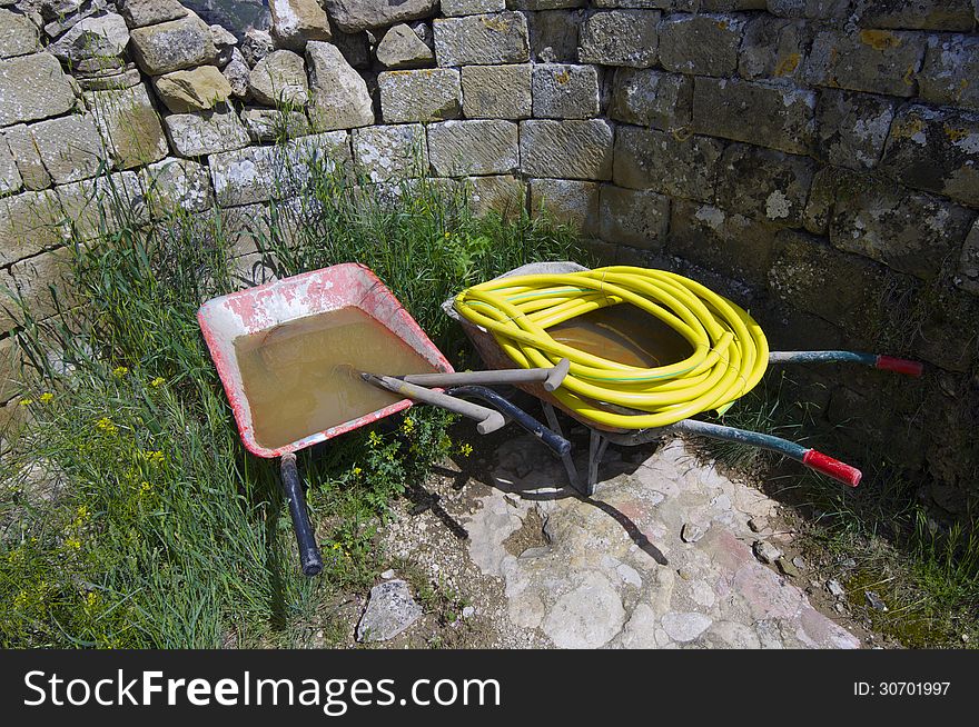 Construction tools next to a stone wall