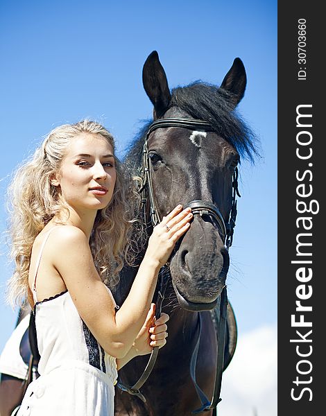 Beautiful girl with black horse at summer field. Beautiful girl with black horse at summer field