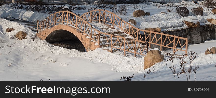 Old arch bridge in the snow, the silent deserted.