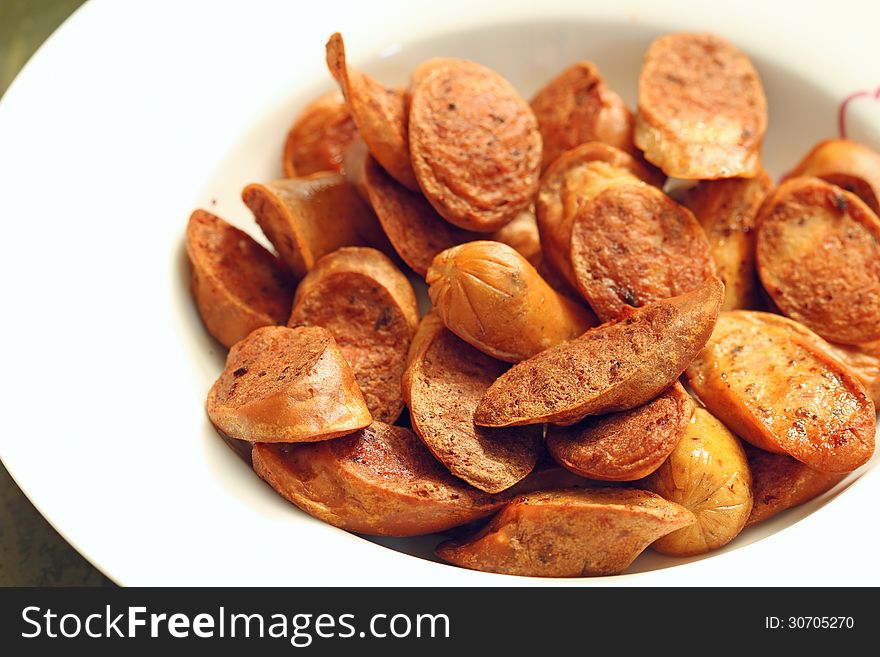 Fried sliced sausage in white dish. Fried sliced sausage in white dish