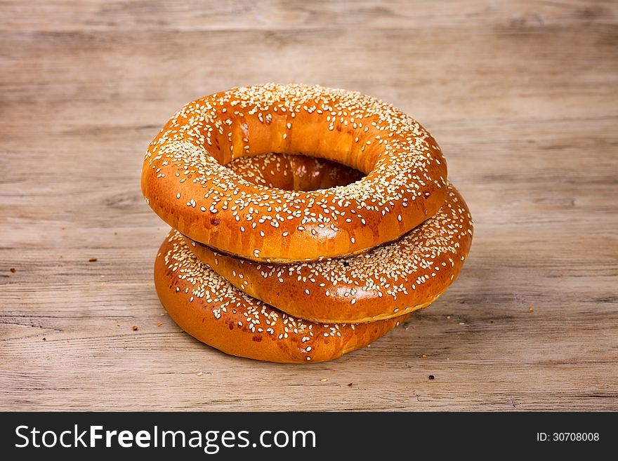 Baked bagels sprinkled with sesame seeds on wood table
