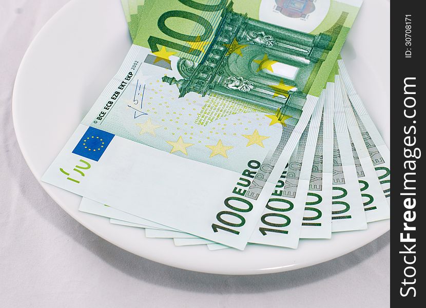 100 euro banknotes on a white plate. 100 euro banknotes on a white plate