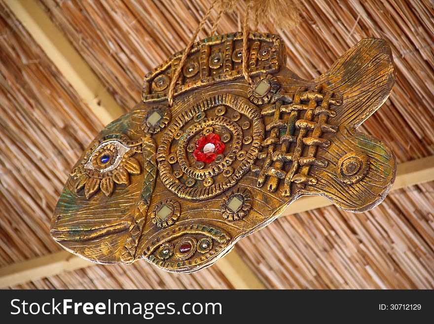 Decorative fish hanging under a thatched ceiling