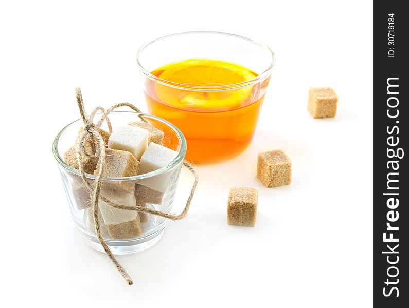 Cup of tea with lemon, sugar cubes and mint on white background