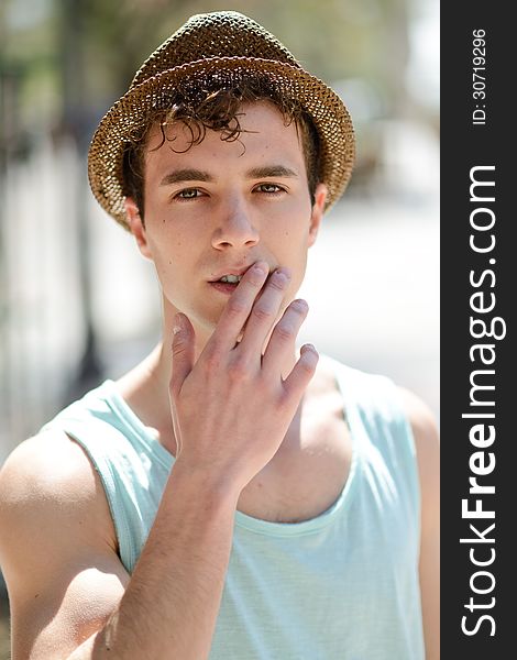 Handsome man wearing sun hat in urban background