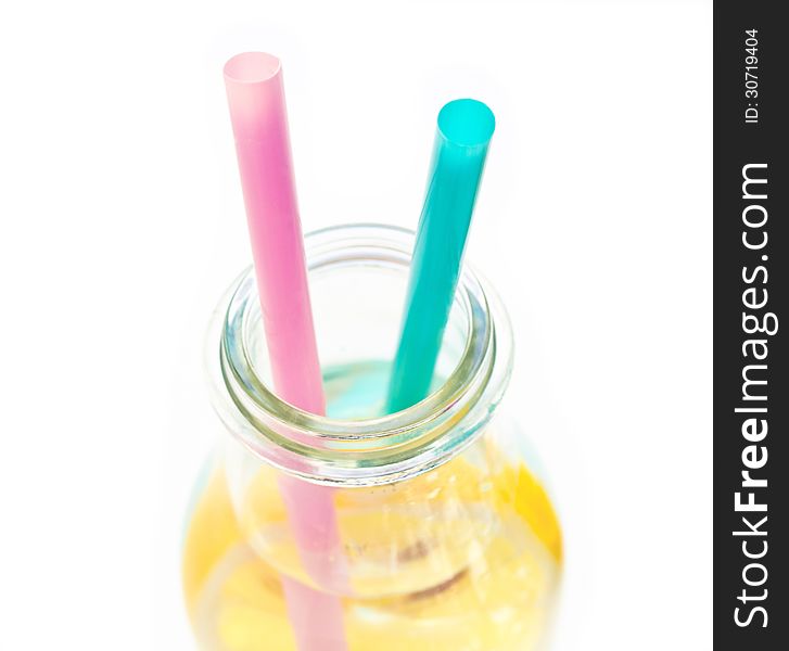 Cold lemon water in a  glass with two straws