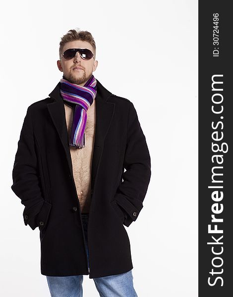 Portrait of handsome stylish blond man in sunglasses and a coat over her naked body in a beautiful stylish scarf