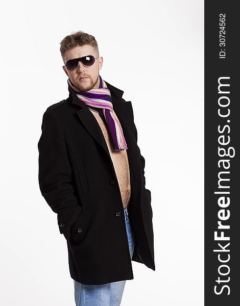 Portrait of handsome stylish blond man in sunglasses and a coat over her naked body in a beautiful stylish scarf