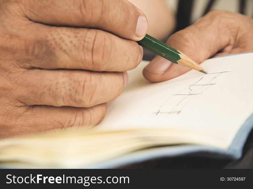 Image of man writing on sketchbook