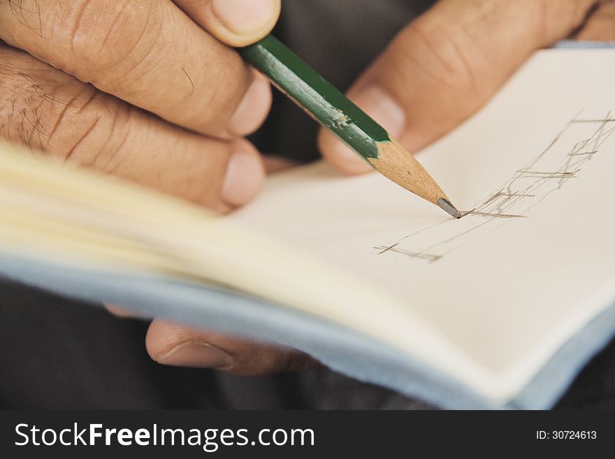 Close up of man writing on sketchbook