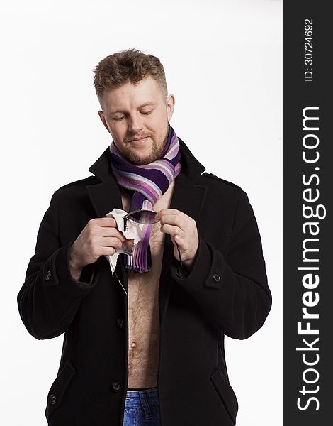 Portrait of handsome stylish blond man in sunglasses and a coat over her naked body in a beautiful stylish scarf
