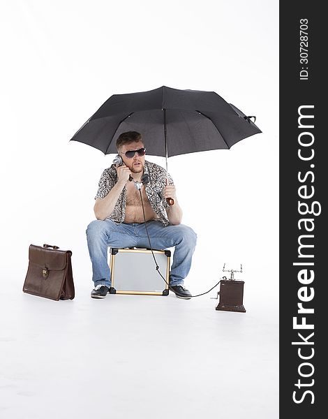 Young businessman under umbrella on vacation. Young businessman under umbrella on vacation