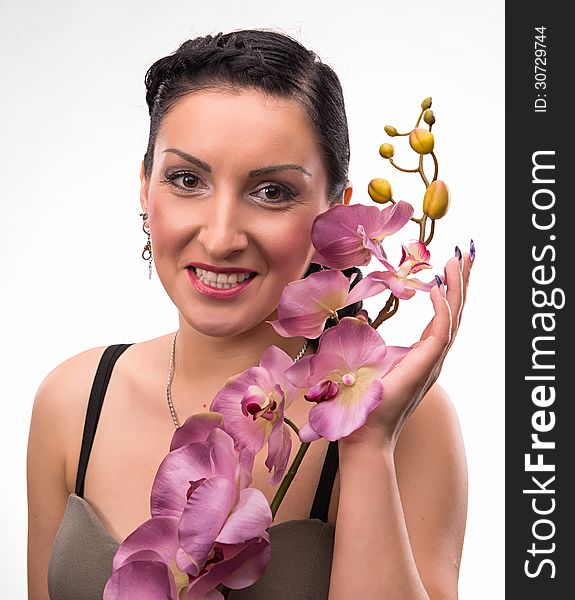 Young woman with beautiful hairstyle and pink orchid on a white background