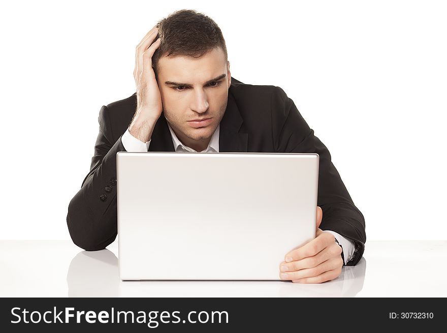 Young businessman stunned and amazed staring at his laptop. Young businessman stunned and amazed staring at his laptop