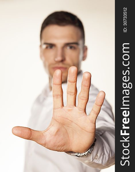Angry attractive young man showing stop hand