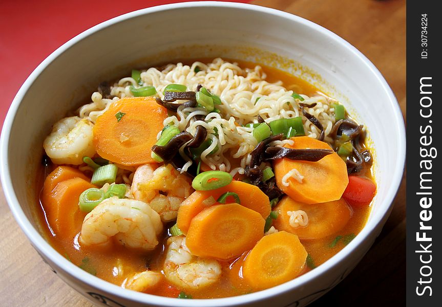 Bowl of Asian noodle soup with prawns and vegetables
